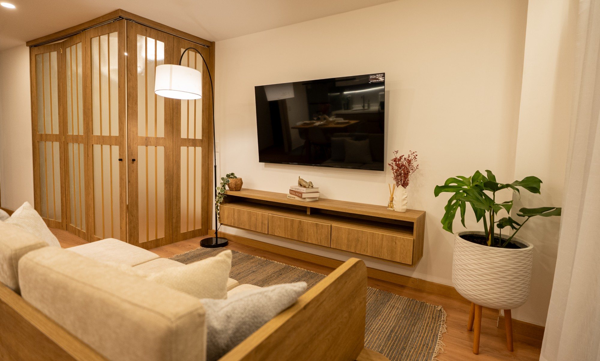 Sala con TV, lámpara y puertas plegables en madera